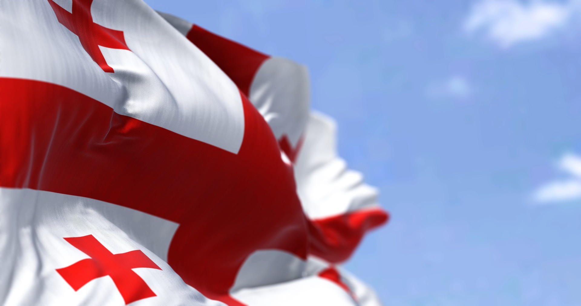Detail of the national flag of Georgia waving in the wind on a clear day